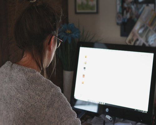 Close up of a person adjusting screen brightness on a monitor