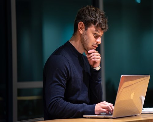 Person looking away from their laptop screen thoughtfully